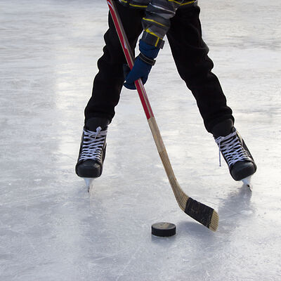 Bild vergr&ouml;&szlig;ern: A hockey amateur teenager ready to hit the puck with the stick